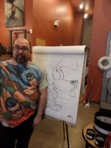 Cartoonist and Toonseum curator Joe Wos alongside one of his quick creations