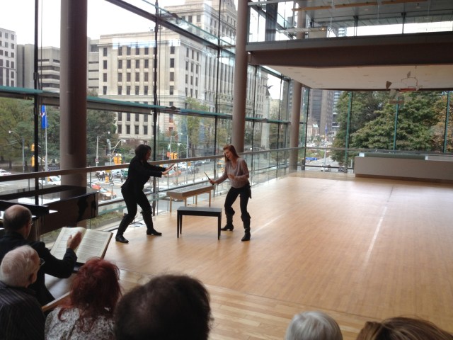 Wallis Giunta (as Bradamante) brandishing a knife in the direction of Allyson  McHardy (as her lover Ruggeiro).